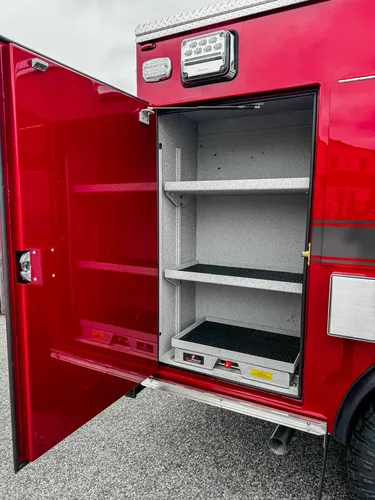 Lower side compartment interior view with shelf and lower tray edge.